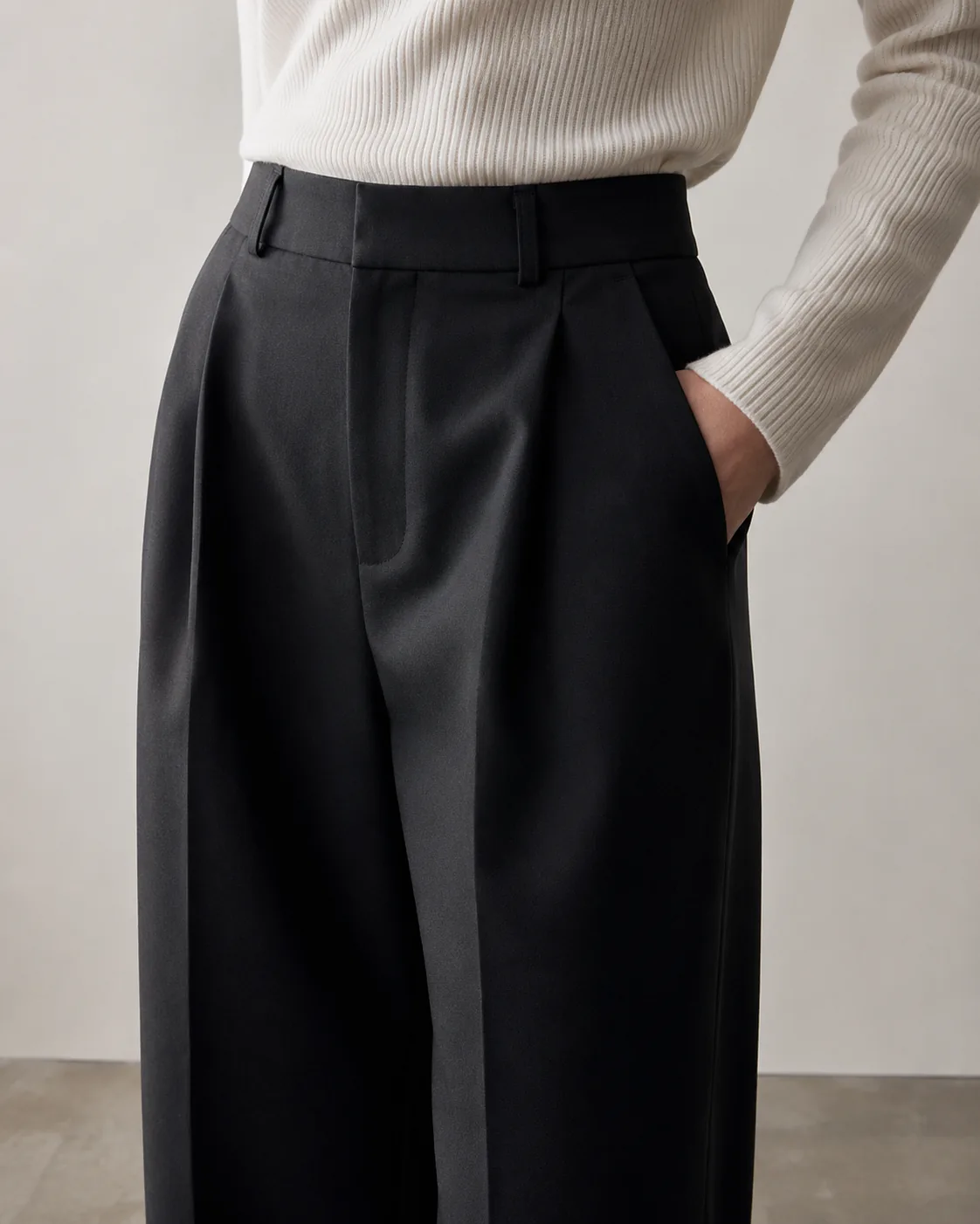 Black tailored trousers with a clean waistband and soft knit top